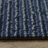 A close-up view of a carpet tile with a striped pattern in various shades of blue and gray, resting on a wooden surface. Produktbild-Vorschau