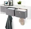 A wall-mounted shelf with fabric storage bins and hooks, holding a shirt and a baseball cap. Voir les images du produit