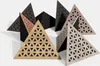 A collection of triangular acoustic foam bass traps with perforated HDF plates arranged on a white surface. Produktbild-Vorschau