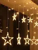 A string of star-shaped lights hanging vertically, illuminated with a warm white glow. Podgląd zdjęcia produktu
