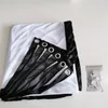 A folded projection screen with grommets and a small bag of accessories on a white background. Produktbild-Vorschau