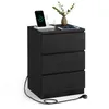 A black three-drawer nightstand with a charging station on top, including a phone and tablet. Náhled obrázku produktu