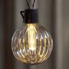 A close-up of a single, illuminated decorative light bulb from a string of lights. Podgląd zdjęcia produktu