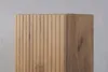 A close-up view of a wooden cabinet with a ribbed texture on one side and a smooth wood grain on the other. Náhľad obrázku produktu
