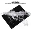 A black anti-slip mat is being rinsed under water, showing bubbles and splashes. Náhľad obrázku produktu