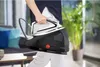 A person is holding a steam generator iron in a modern living room setting. Náhľad obrázku produktu