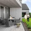 A couple walks on a lawn next to a modern house with a patio set on the deck. Náhľad obrázku produktu