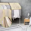 A garment rack covered with a protective cloth, with clothes hanging inside. A close-up inset shows velcro fasteners. Produktbild-Vorschau