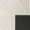 A close-up view of a textured rug with a geometric pattern and a dark backing. Anteprima dell’immagine prodotto