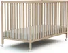 A light-colored wooden baby crib with a mattress inside, shown from a side angle with wheels visible at the bottom. Anteprima dell’immagine prodotto