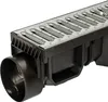 A close-up, angled view of a drainage channel system with a metal grate and a black plastic outlet pipe. Anteprima dell’immagine prodotto
