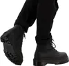 A close-up shot of a person wearing black Dr. Martens boots and black pants. Anteprima dell’immagine prodotto