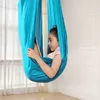 A young girl is relaxing in a blue hammock, reading on a tablet. Náhled obrázku produktu
