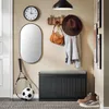 An entryway with a shoe cabinet, mirror, clock, coat rack, and sports equipment. Produktbild-Vorschau