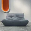 A grey sofa is shown in a room with a white wall and a decorative orange light fixture. Anteprima dell’immagine prodotto