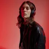 A person wearing headphones against a red background. Podgląd zdjęcia produktu