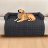 A dog is lying on a dark gray pet bed placed on a sofa. Náhled obrázku produktu