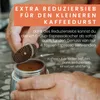 A person is holding a coffee maker and demonstrating how to use a reducer sieve. Produktbild-Vorschau