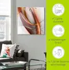 A wall clock with an abstract design is displayed on a wall above a sofa. To the right of the clock, there are marketing icons and text highlighting product features. Produktbild-Vorschau