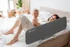 A mother and baby are lying on a bed with a bed rail installed. Voir les images du produit