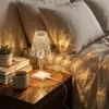A bedside table with a lamp, books, and a mug of tea. Produktbild-Vorschau