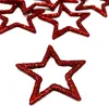 A collection of red glitter star-shaped decorations scattered on a white background, with one star prominently in the foreground. Produktbild-Vorschau