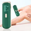 A hand is holding a green hair removal device on a person's leg. Produktbild-Vorschau