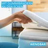 Hands placing a mattress topper onto a mattress. Produktbild-Vorschau