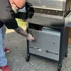 A man is shown interacting with a grill, possibly opening a compartment. Anteprima dell’immagine prodotto
