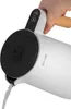 A hand is holding a white electric kettle and pouring water from it. Produktbild-Vorschau