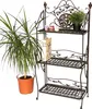 A metal shelf unit with decorative elements, holding a plant, a book, and small jars. Anteprima dell’immagine prodotto