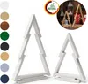 Two white wooden Christmas tree decorations are displayed against a white background. A circular inset image shows two wooden Christmas tree decorations in a rustic setting with lanterns and gifts. Náhľad obrázku produktu
