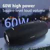 A black portable speaker is shown outdoors at night with blurred lights in the background. Produktbild-Vorschau
