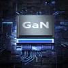 A close-up of a GaN chip on a dark, futuristic circuit board with glowing blue lines. Voir les images du produit