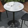 A round marble-patterned table with two chairs on a patio. Anteprima dell’immagine prodotto