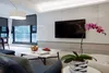 A modern living room with a TV, sofa, coffee table, and a plant. Voir les images du produit