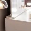 A close-up view of a white vanity table with a mirror and LED lights. Voir les images du produit