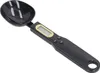 A black digital spoon scale with a gold-rimmed LCD screen and three buttons on the handle, shown on a white background. Náhľad obrázku produktu