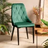 A green velvet chair is placed in a room with plants and decorative items. Náhľad obrázku produktu
