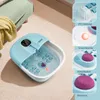 A foot spa bath is shown on a carpeted floor next to a chair with a yellow blanket. The image also includes inset images highlighting product features. Anteprima dell’immagine prodotto