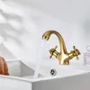 A brass faucet with water running into a white sink. Podgląd zdjęcia produktu