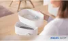 A person is holding a top part of a baby bottle sterilizer over the base unit. Produktbild-Vorschau