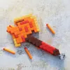 A Minecraft-themed Nerf axe blaster with darts on a textured surface. Podgląd zdjęcia produktu