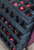 A close-up view of a storage organizer filled with red Christmas ornaments. Podgląd zdjęcia produktu
