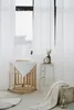 A nursery room with a crib, blankets, and a stuffed animal. Anteprima dell’immagine prodotto