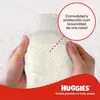 Hands holding a diaper, with a circular callout highlighting its features. Produktbild-Vorschau