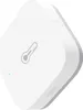 A white, diamond-shaped temperature and humidity sensor with a thermometer icon and the brand name 'Aqara' printed on it. Voir les images du produit