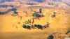 A group of people stand on a rocky outcrop in a desert landscape. Produktbild-Vorschau