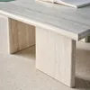 Close-up of a travertine-look coffee table with a book on top. Produktbild-Vorschau