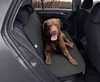 A brown dog is sitting on a black car seat cover in the back seat of a car. Anteprima dell’immagine prodotto
